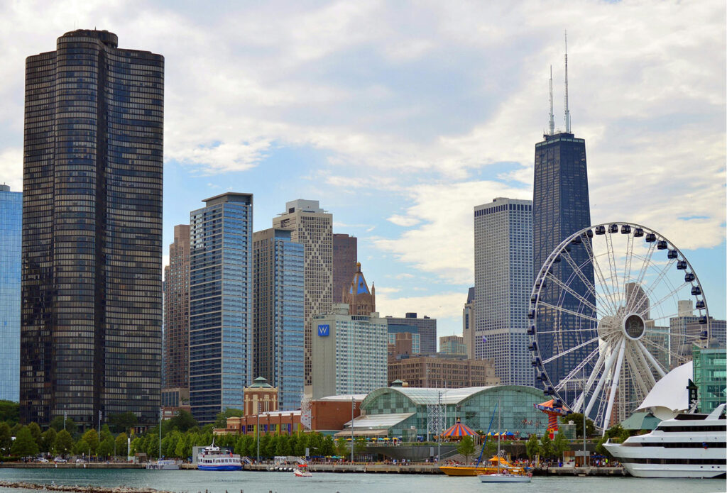 Chicago skyline featuring Navy Pier, Ferris wheel, and surrounding skyscrapers on a bright, cloudy day.